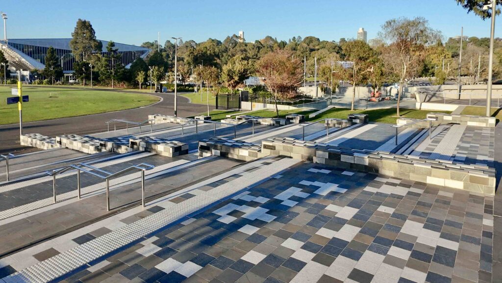 Wide-angle view of the grand stone staircases and patterned plazas at Rod Laver Arena, featuring multi-toned pavers and solid block seating supplied by Eigen Stones.