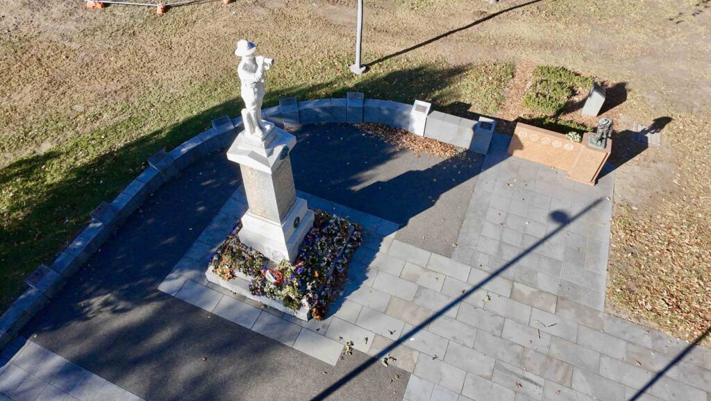 An aerial view of the Box Hill Memorial showing the central soldier statue on a paved stone area, with a curved memorial wall in the background, all featuring stone supplied by Eigen Stones.