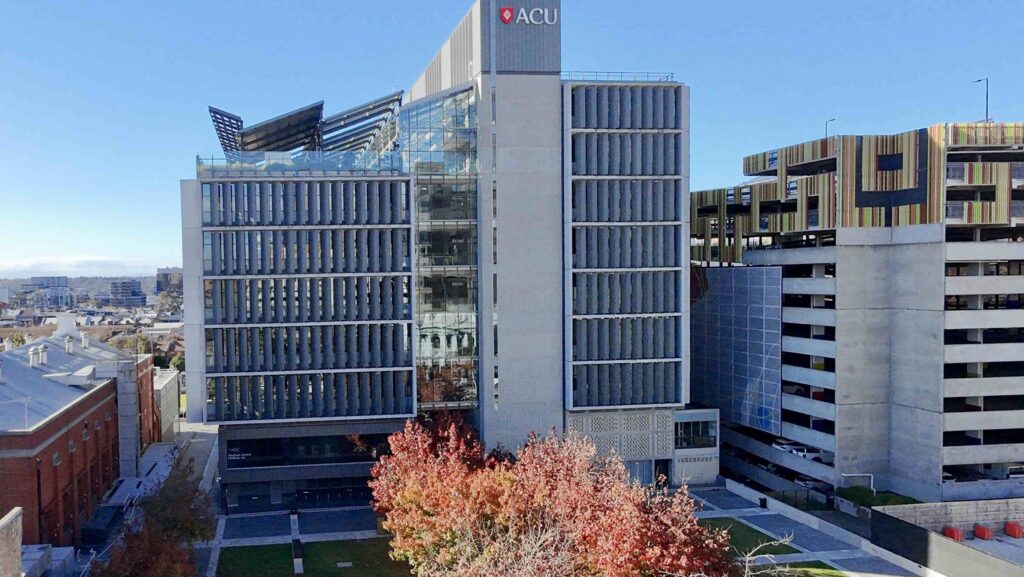 The long, patterned stone laneway at the Victorian Women's Centre, featuring integrated seating and planters, with all pavers supplied by Eigen Stones.