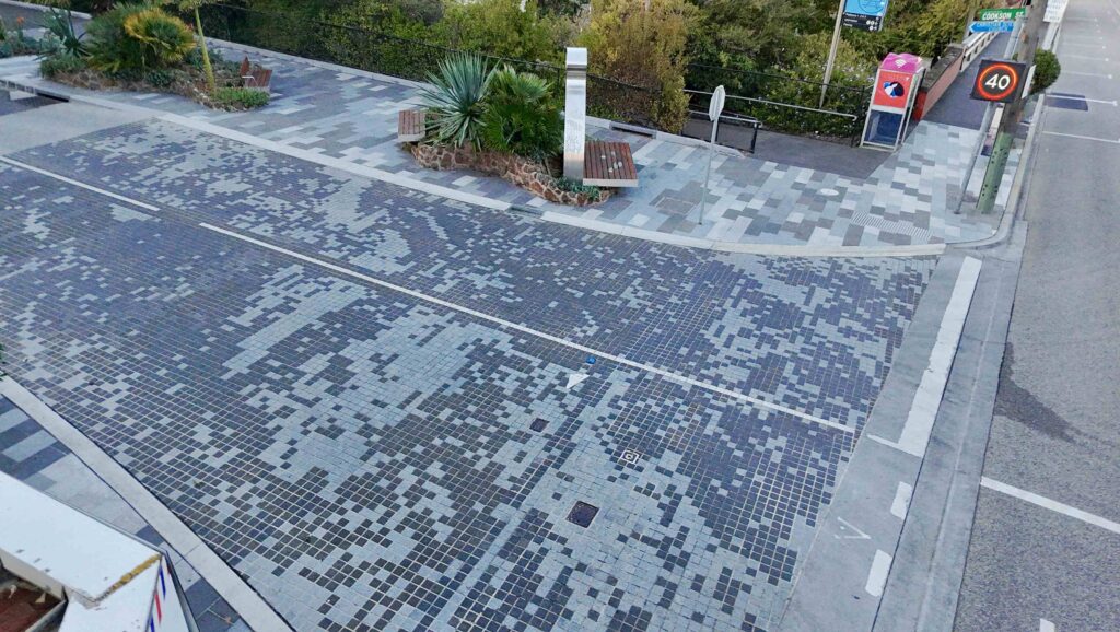 A gracefully curving pathway at RMIT Bundoora, created with light-toned stone cobblestones supplied by Eigen Stones, forks into two directions through a newly landscaped area.