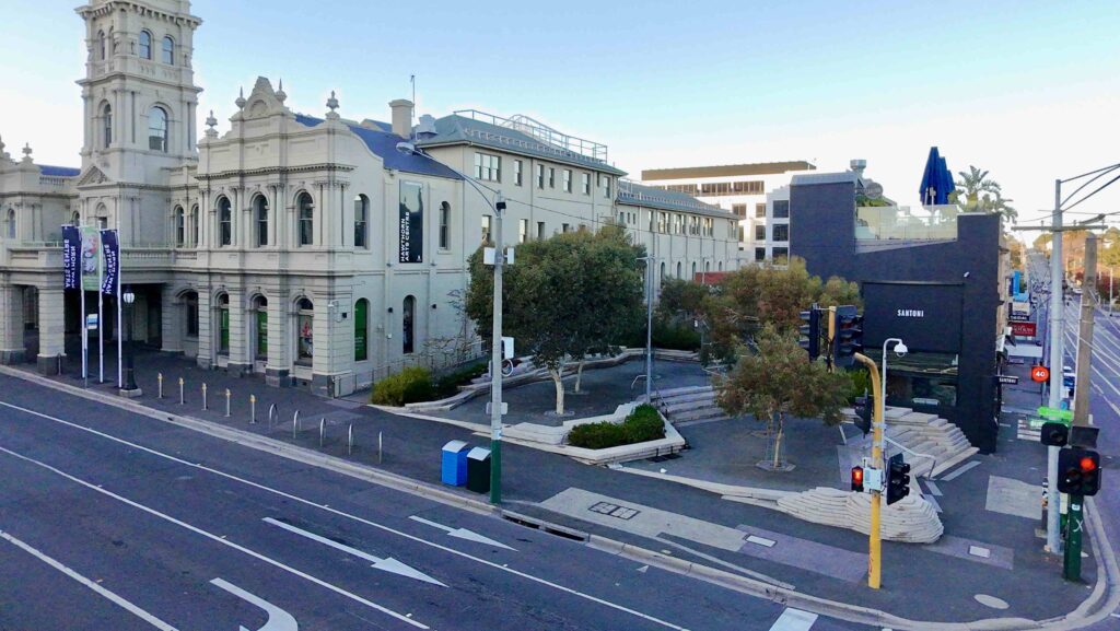 A top-down view of the textured stone paving at Hampshire St, showing integrated line markings and tactile pavers from Eigen Stones.