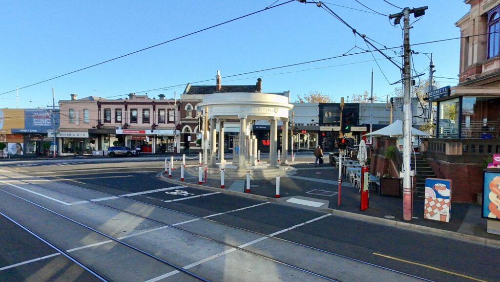 The Kew Memorial standing as a proud landmark in a busy streetscape, its enduring stone presence captured in a street-level view. Stone supplied by Eigen Stones.