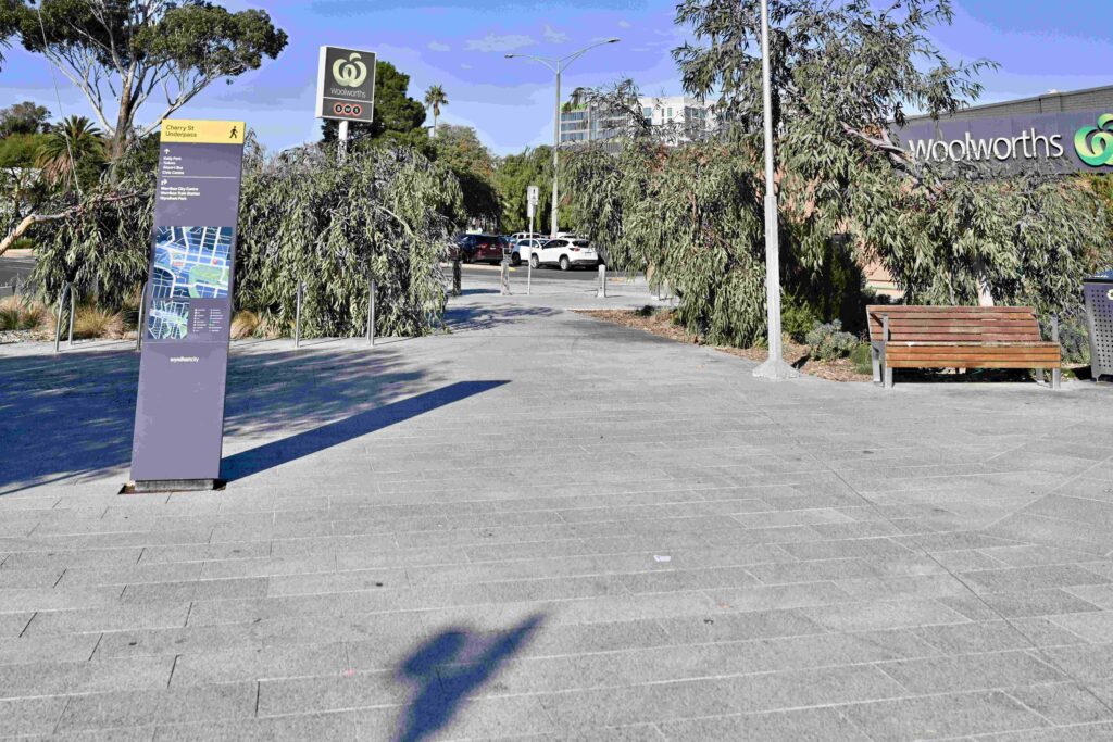 A clean, modern stone-paved walkway at the Werribee Station precinct, leading towards a retail area, with materials supplied by Eigen Stones.