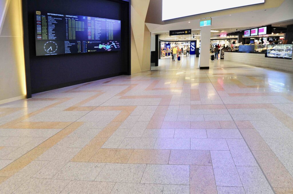 A dynamic, geometric pattern in the two-toned stone floor supplied by Eigen Stones, guiding travellers past the international departure boards at Melbourne Airport.