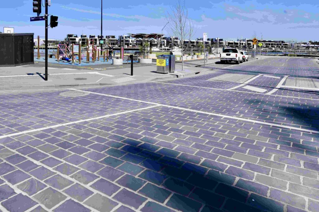 A shared street zone in Docklands paved with durable, dark stone cobblestones supplied by Eigen Stones, leading to a children's playground.
