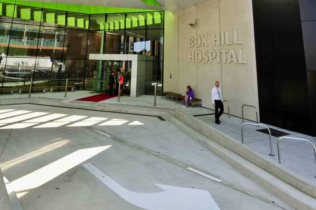 The main entrance of the modern Box Hill Hospital, showing the clean lines of the stone-paved drop-off area and walkways supplied by Eigen Stones.