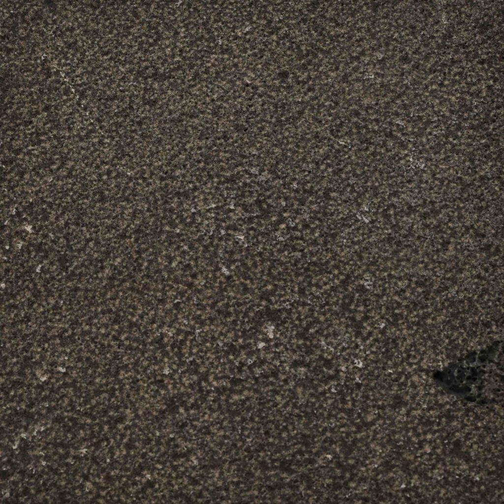 BlueStone_BH+WJ.jpg: A detailed macro shot of the Blue Stone Bush Hammered paver, showcasing its deep, earthy tones and finely textured, non-reflective surface.